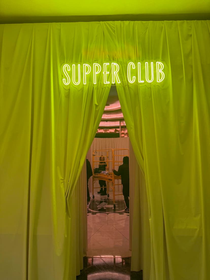 Supper Club neon sign with dramatic green-lit curtain entrance