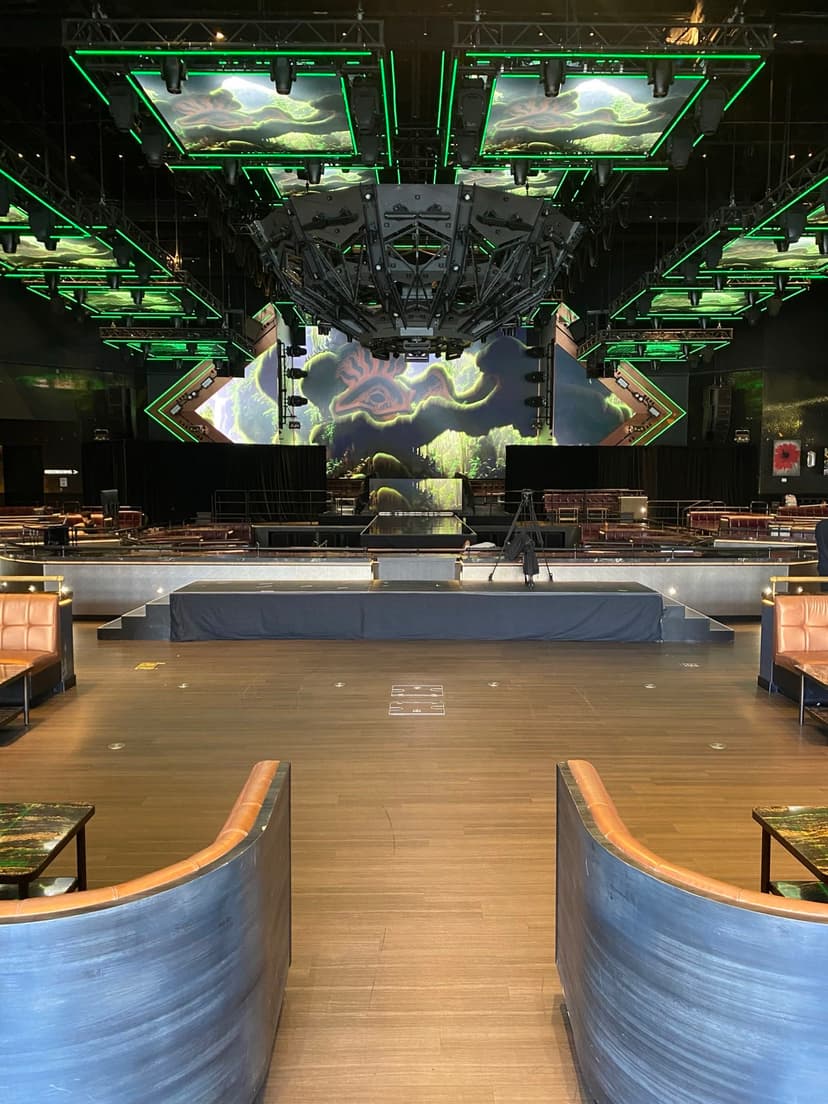 Concert stage setup with dramatic green lighting and LED screens